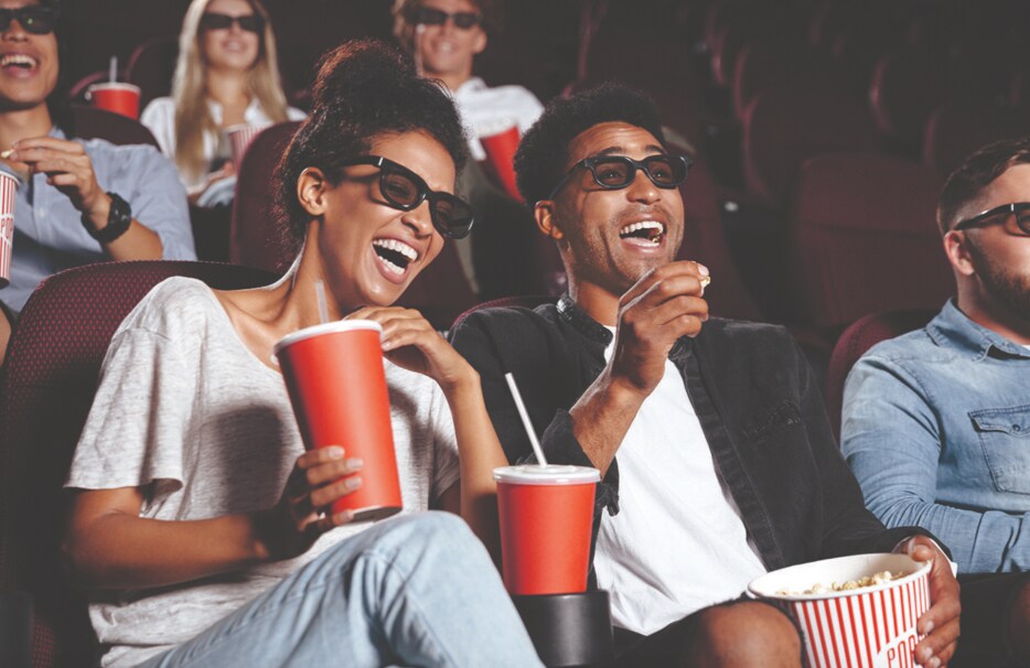 Couple enjoying snacks and drinks at the movie theater.