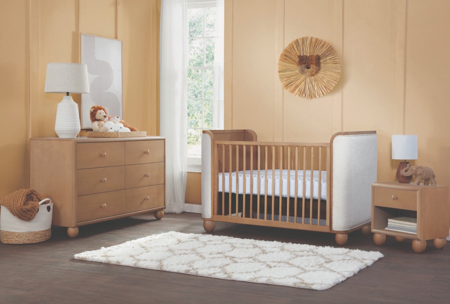 Chambre de bébé avec lit, commode, table de nuit et tapis