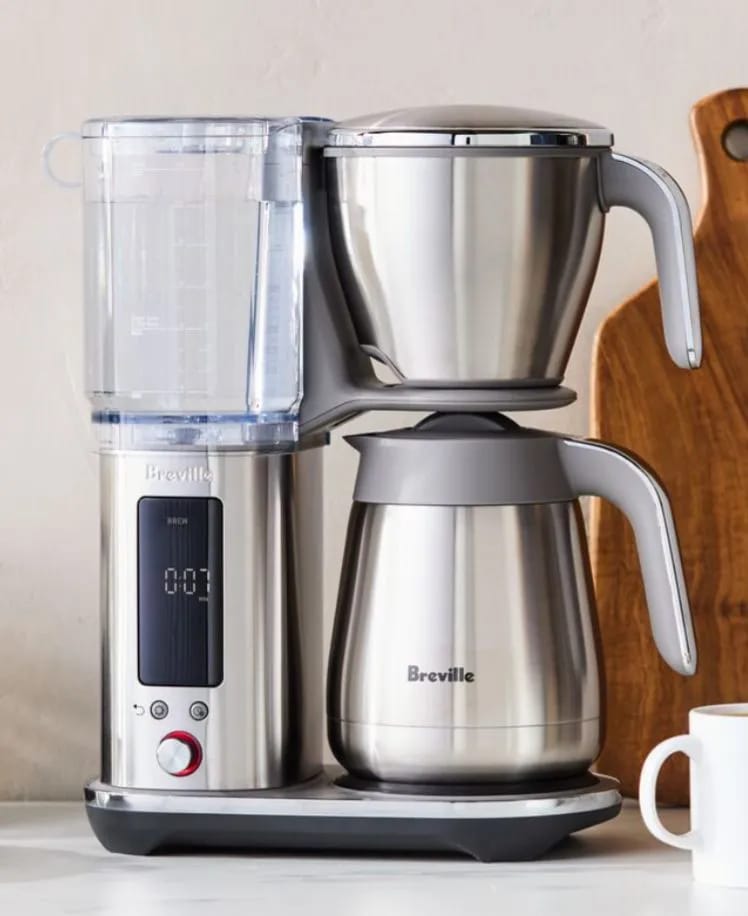 Modern stainless steel coffee maker with digital display on a kitchen countertop