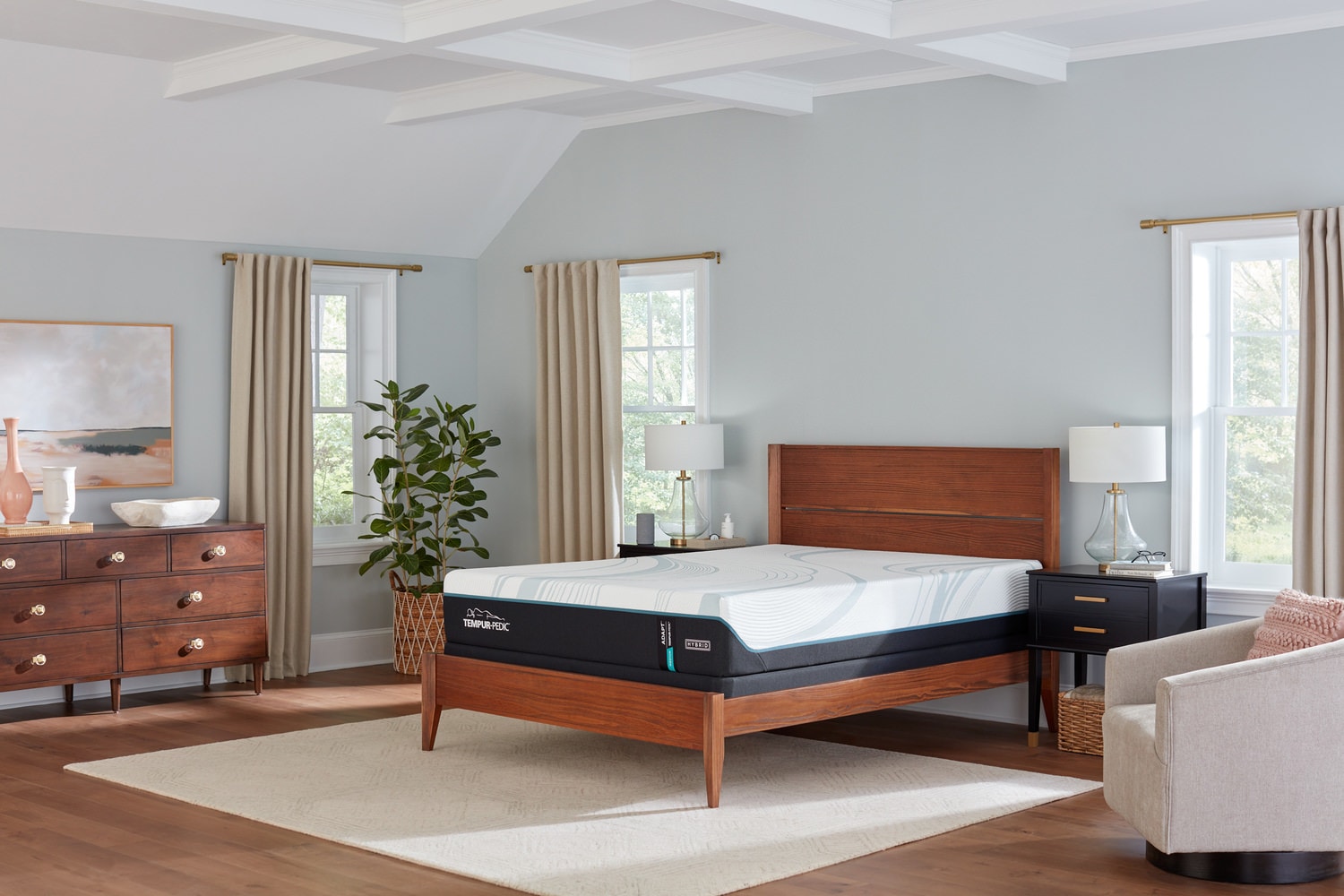Modern bedroom with a large bed, dresser, two windows, a plant, and beige walls