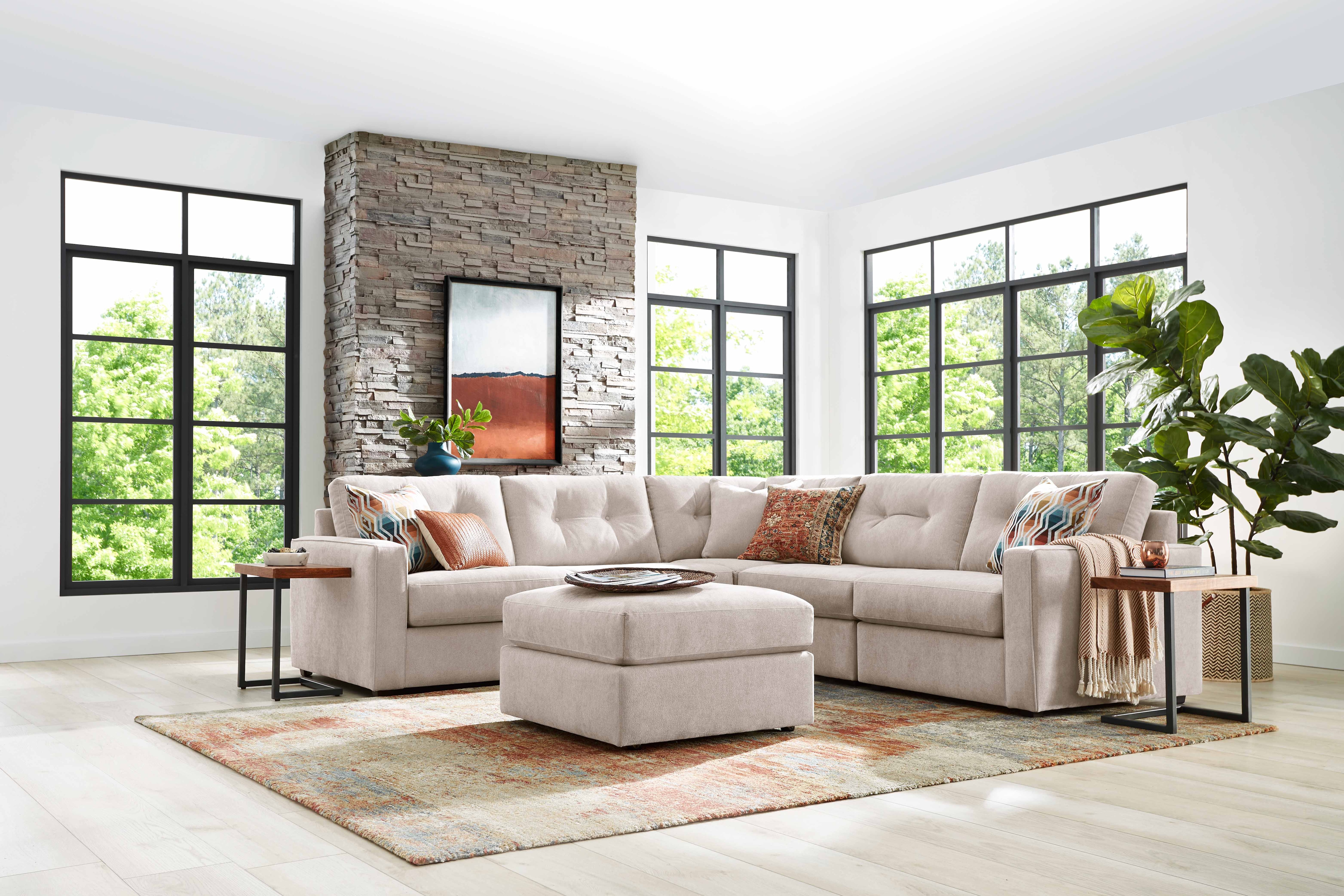 Modern living room with a sectional sofa, large windows, and a brick accent wall